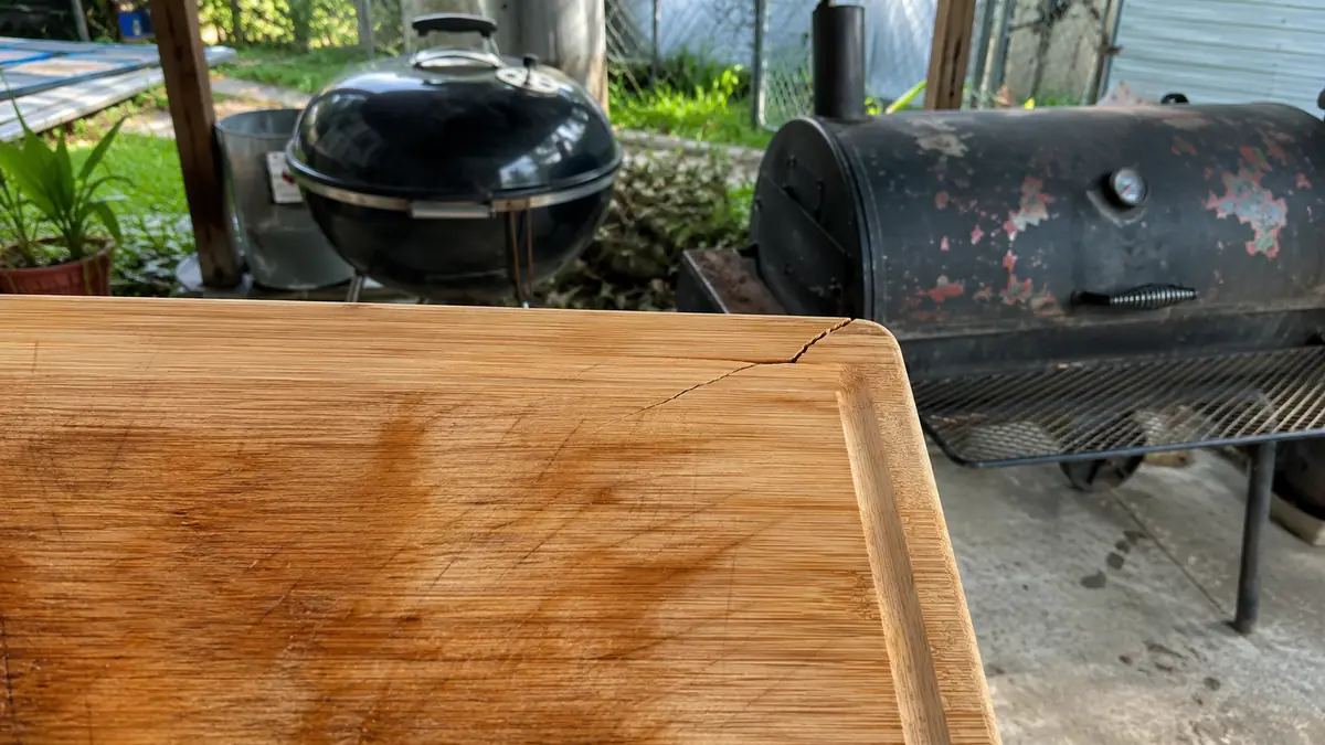 A hairline crack near the corner of a bamboo carving board, close up